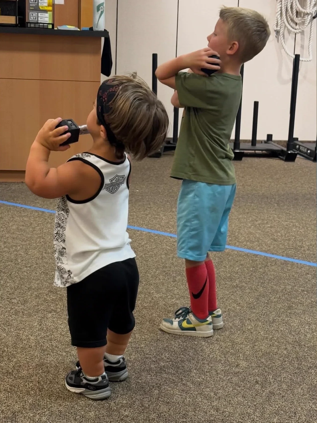 Kids holding weights during Homeschool Gym Class at Elevate Motion